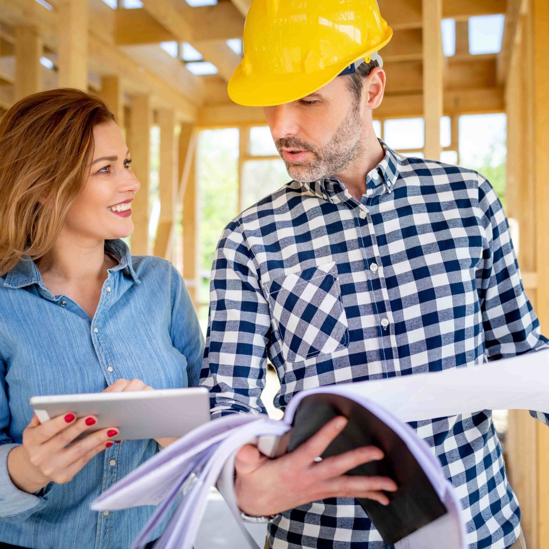 Female homeowner consults blueprints with Architec